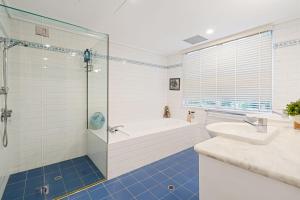 un bagno con vasca, lavandino e doccia di Villa San Michele a Coolum Beach Altre 21 foto