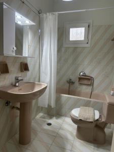 un bagno con lavandino, WC e vasca di Maria's Cottage a Città di Lefkada Altre 61 foto