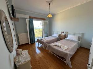 una camera da letto con due letti e una finestra di Maria's Cottage a Città di Lefkada