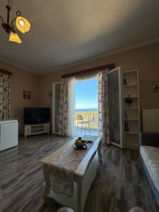 un soggiorno con un tavolo e una grande finestra di Maria's Cottage a Città di Lefkada
