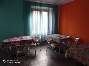 a room with two tables and chairs and a window at B&B Leo in Aviatico