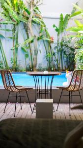 una mesa con dos sillas y una mesa con un pájaro. en Saxy Stay Seminyak, en Seminyak