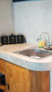 Una encimera de cocina con fregadero y tres relojes. en Saxy Stay Seminyak, en Seminyak 12 fotos más