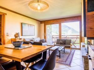 a living room with a table and a couch at Apt 102, Les Chalets du Chaberton, pied de pistes et Spa in Montgenèvre