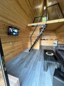 a room with a couch and a tv in a cabin at Green Garden  +1 photo