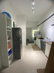 a kitchen with a black refrigerator in a room at Puteri Elaisha Homestay in Batu Arang