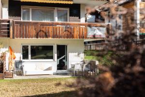 a house with a deck and a patio with chairs at Appartement 2 chambres et terrasse in Zermatt