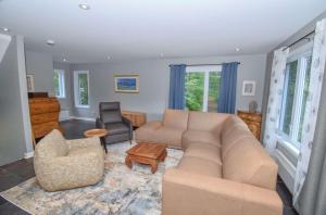 a living room with a couch and a chair at Spa Nature Waterfront - Le Cardinal in Ripon