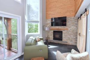 a living room with a fireplace and a tv at Spa Nature Waterfront - Le Cardinal in Ripon