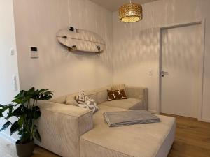 a living room with a couch and a surfboard on the wall at Zentrale Citywohnung Bayreuth, Loggia, Garage in Bayreuth