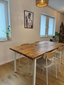 a wooden table in a dining room with chairs at Zentrale Citywohnung Bayreuth, Loggia, Garage in Bayreuth +10 photos