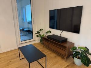 a living room with a large flat screen tv on a wall at Zentrale Citywohnung Bayreuth, Loggia, Garage in Bayreuth