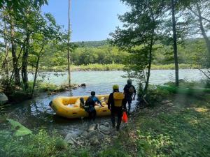 un gruppo di persone in piedi accanto a una zattera su un fiume di Snow Resort Hermitage a Asahikawa