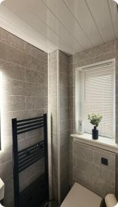 Un baño con inodoro y ventana. en Edinburgh city break room, en Edimburgo