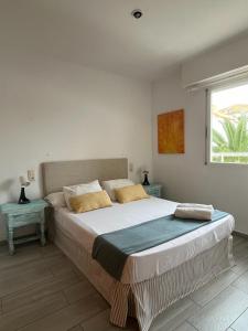 a bedroom with a bed with two tables and a window at Apartamento frente al mar, Talima in Denia