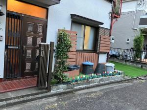 a house with a fence and flowers in front of it at Yuzu House - Vacation STAY 19174 in Chofu