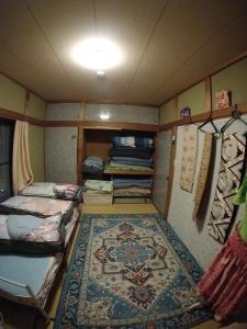 a small room with beds and a rug in it at Yuzu House - Vacation STAY 19174 in Chofu