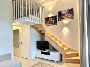 a living room with a staircase and a tv at Coeur de Ville in Nantes