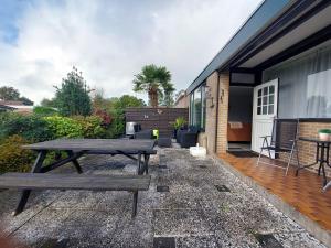 a patio with a wooden table and a picnic table at Plattedijk - vakantiehuis 25-41 in Lemmer