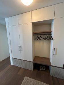 a large white cabinet with hangers in a room at Casa Partnun 4-3 in Laax-Murschetg
