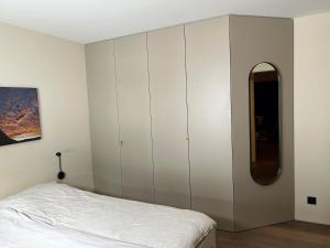 a bedroom with a bed and a large white cabinet at Casa Partnun 4-3 in Laax-Murschetg