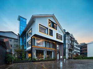 un gran edificio con ventanas en una calle de la ciudad en Zhangjiajie National Park RU Hotel--Free one way pick up service over 2 night,Free fresh coffee,Attraction Tickets Serivce in advance, en Hanqiyu