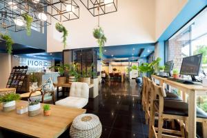 a store with tables and chairs and plants at MORE Patong Hotel in Patong Beach