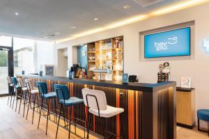a bar with blue and white bar stools at Hey Lou Hotel Friedrichshafen in Friedrichshafen