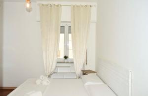 a white room with a bed and a window at La Petite Room in Otranto