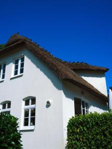 ein weißes Haus mit einem Strohdach in der Unterkunft Ferienhaus Pauline in Glücksburg