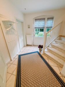 einen Flur mit Treppe und einem Teppich auf dem Boden in der Unterkunft Ferienhaus Pauline in Glücksburg