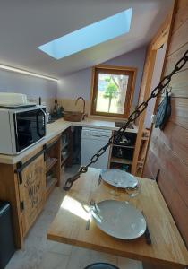 a kitchen with a wooden table with plates on it at Cabane Wood & Spa in Chasselay