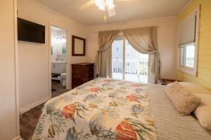 a bedroom with a bed and a television and a window at Genesis On The Water, Views! Views! Views! in Rodanthe