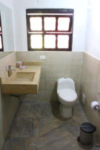 uma casa de banho com um WC, um lavatório e uma janela em Posada San Martin em Villa de Leyva