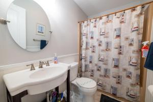 a bathroom with a sink and a toilet and a mirror at Genesis On The Water, Views! Views! Views! in Rodanthe