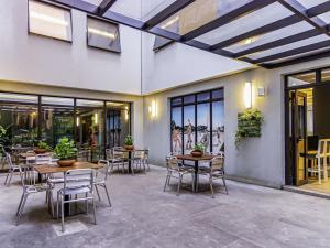 a patio with tables and chairs and windows at ibis Styles Rio de Janeiro Botafogo in Rio de Janeiro