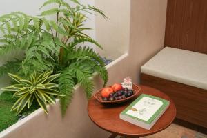 a table with a bowl of fruit and a book at Floral Hotel Yinshiyi Chang'an, Xi'an Bell and Drum Tower Sajinqiao Subway Station in Xi'an