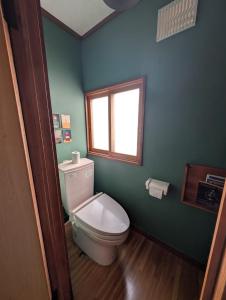 a bathroom with a toilet and a window at Migiwa House in Rankoshi