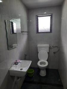 a bathroom with a toilet and a sink and a window at Hotel Green Forest Mahableshwar in Mahabaleshwar