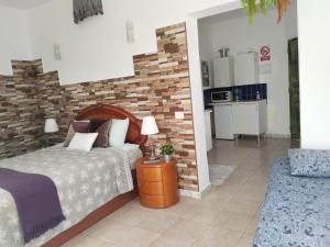 Un dormitorio con una cama y una pared de ladrillo. en Happy Home, en Garachico