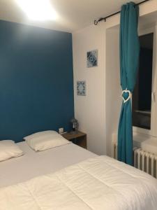 a bedroom with a bed and a blue wall at Villa Blanche appartement 2 in Le Mont-Dore