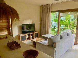 a living room with a couch and a television at La Bonita Lodge in Puerto Viejo