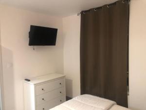 a bedroom with a bed and a television on the wall at Villa Blanche appartement 2 in Le Mont-Dore