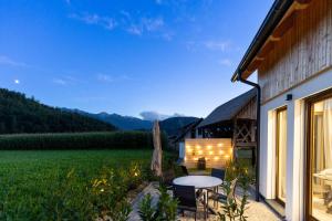 a patio with a table and chairs and a field at Cherryhood Chalet in Bohinj