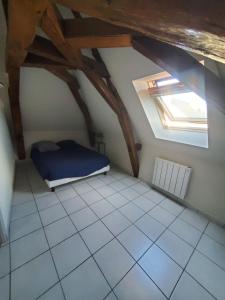 a attic room with a bed and a window at Idéal famille, 2 chambres au calme in Bourgueil
