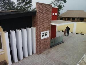 a brick building with white doors and people walking outside at Rikkies Place Hotel in Lagos