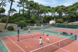a group of people playing tennis on a tennis court at Belambra Clubs Capbreton - Les Vignes in Capbreton