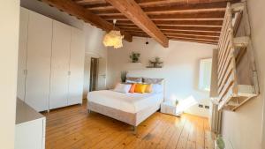 Schlafzimmer mit einem weißen Bett und Holzböden in der Unterkunft Sky View Residenza - Roofview free parking in Verona