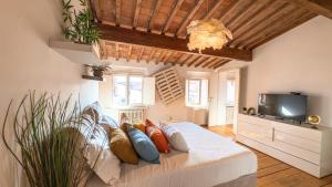 Schlafzimmer mit einem Bett mit Kissen und einem TV in der Unterkunft Sky View Residenza - Roofview free parking in Verona