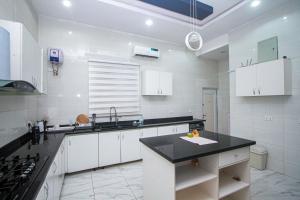 a kitchen with white cabinets and a black counter top at Dreamscape in Maiyegun